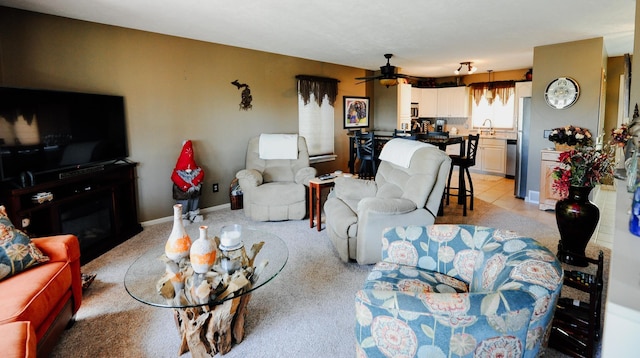 living area featuring light colored carpet and a ceiling fan