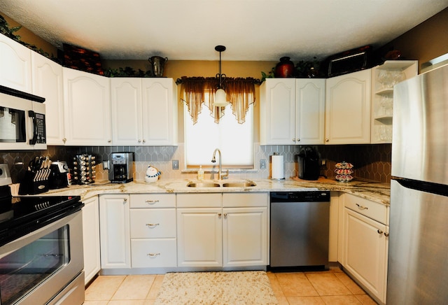 kitchen featuring stainless steel appliances, a sink, light stone countertops, and light tile patterned floors