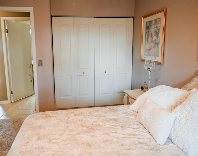 bedroom with a closet, tile patterned floors, and baseboards