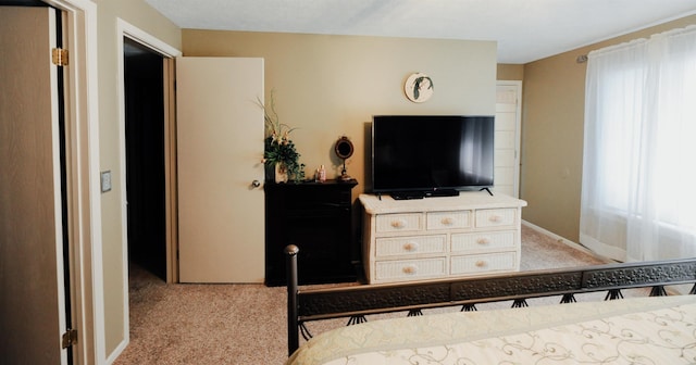 bedroom with light colored carpet, multiple windows, and baseboards