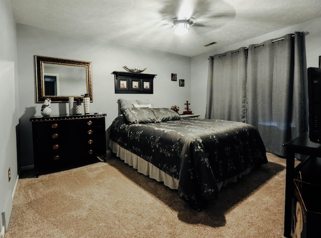 carpeted bedroom with a ceiling fan and a textured ceiling