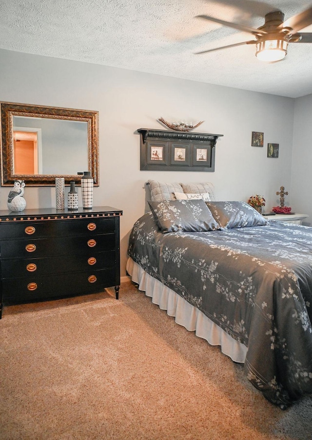carpeted bedroom featuring ceiling fan and a textured ceiling
