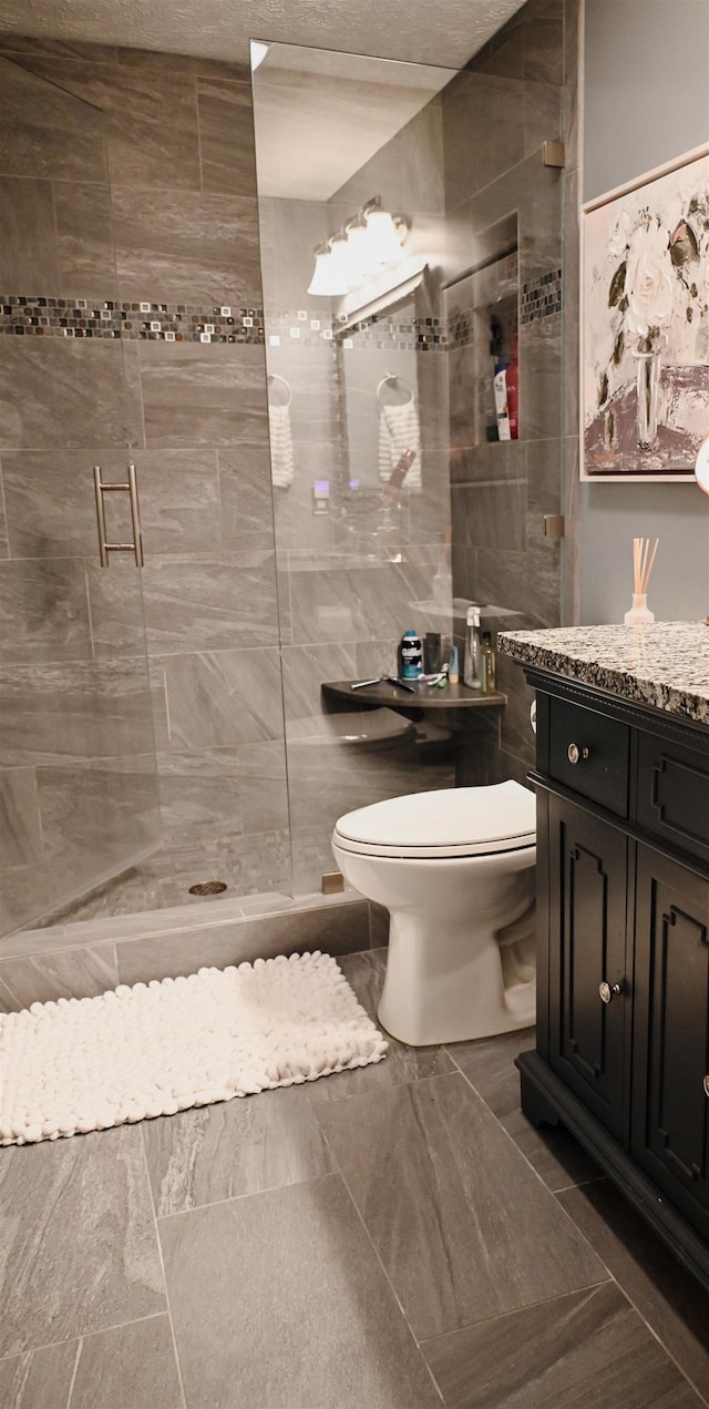 full bathroom with toilet, a shower stall, and vanity