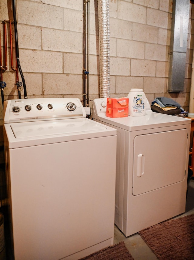 washroom featuring separate washer and dryer and concrete block wall