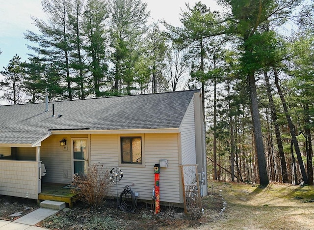 view of front of house with roof with shingles and a wooden deck