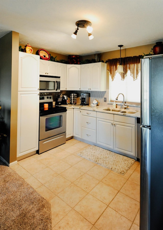 kitchen featuring stainless steel appliances, a sink, light countertops, and backsplash
