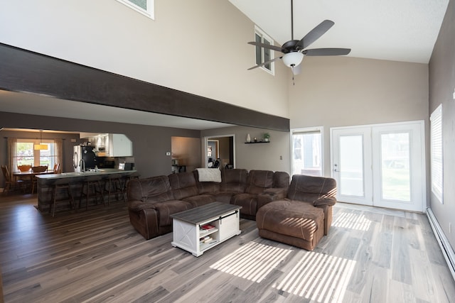 472 Central St, Marysville, MI 48040 - living area featuring high vaulted ceiling, baseboard heating, wood finished floors, and ceiling fan