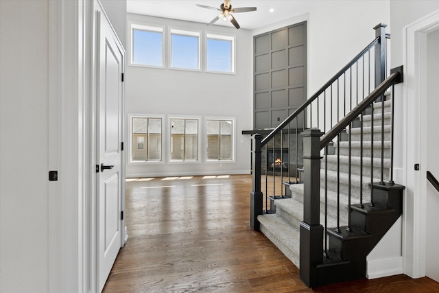 19266 Thompson Dr, Macomb, MI 48042 - foyer entrance featuring a ceiling fan, wood finished floors, stairs, baseboards, and a high ceiling