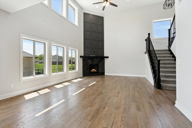 19266 Thompson Dr, Macomb, MI 48042 - unfurnished living room featuring baseboards, plenty of natural light, ceiling fan, wood finished floors, and a towering ceiling