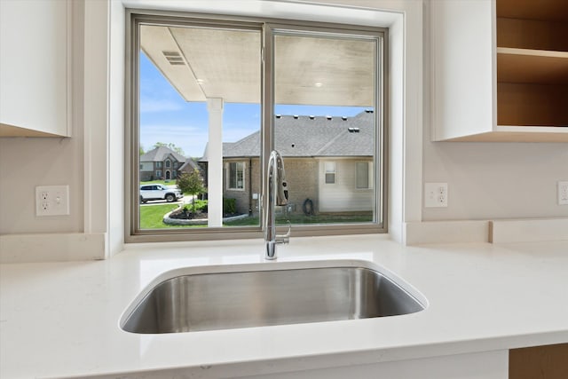 19266 Thompson Dr, Macomb, MI 48042 - kitchen view of a sink, white cabinetry, and light countertops