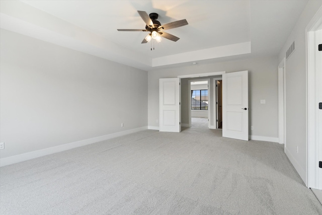 19266 Thompson Dr, Macomb, MI 48042 - unfurnished bedroom with a raised ceiling, light carpet, baseboards, and a ceiling fan