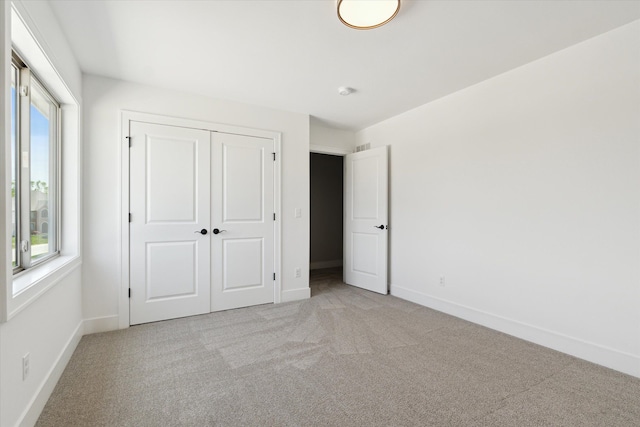 19266 Thompson Dr, Macomb, MI 48042 - unfurnished bedroom with light carpet, baseboards, and a closet