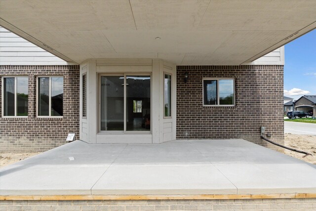 19266 Thompson Dr, Macomb, MI 48042 - view of exterior entry with a patio area and brick siding