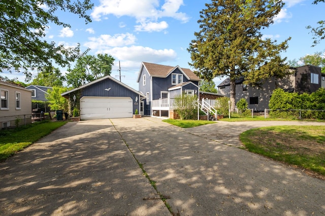 view of front facade featuring an outdoor structure, board and batten siding, driveway, and a detached garage
