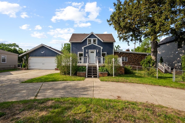 view of front of home with fence, driveway, and a detached garage