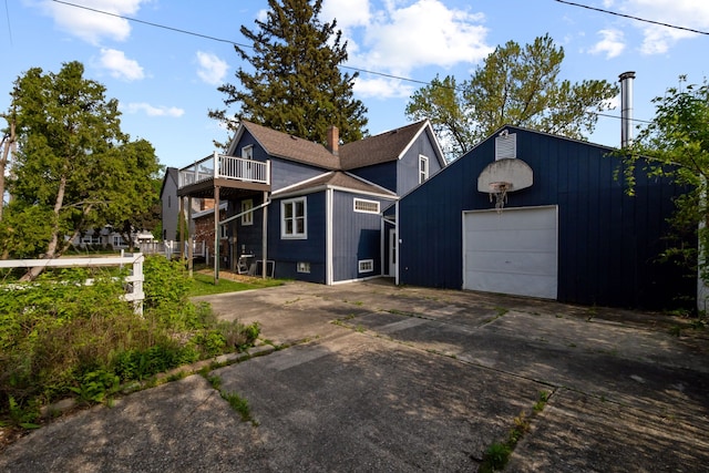 view of front facade with a garage, concrete driveway, and an outbuilding
