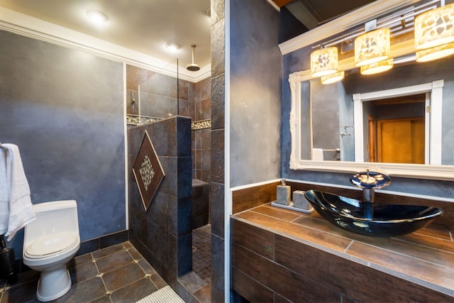 full bathroom featuring a sink, toilet, walk in shower, ornamental molding, and tile patterned floors