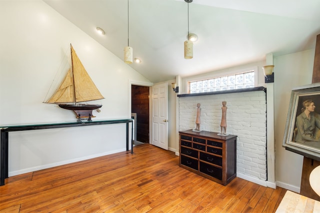 living room with vaulted ceiling, wood finished floors, and baseboards