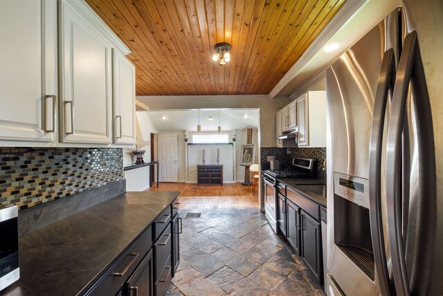 kitchen with appliances with stainless steel finishes, dark countertops, crown molding, wooden ceiling, and white cabinets