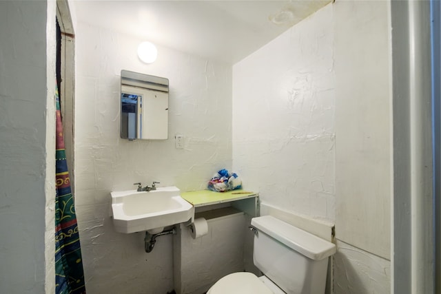 full bath featuring toilet and a sink