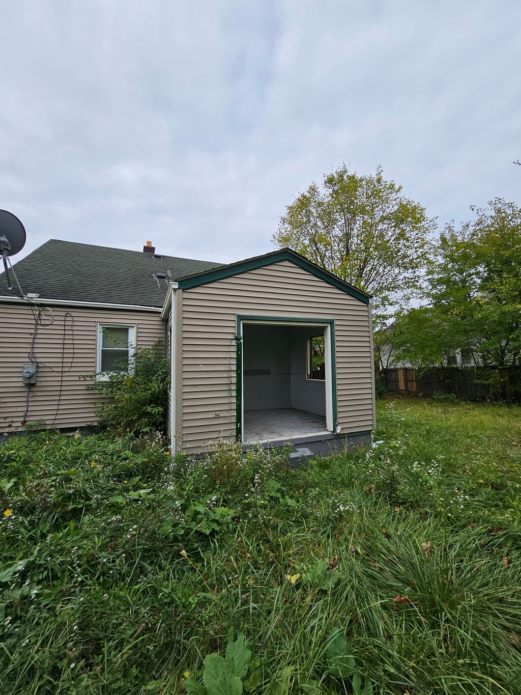 7396 Stahelin Ave, Detroit, MI 48228 - view of property exterior featuring fence, roof with shingles, and an outdoor structure