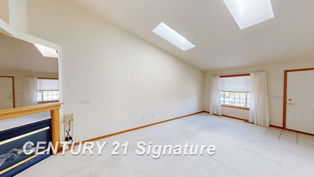 5966 Red Feather Dr, Bay City, MI 48706 - unfurnished living room featuring a skylight, lofted ceiling, carpet flooring, baseboards, and a fireplace