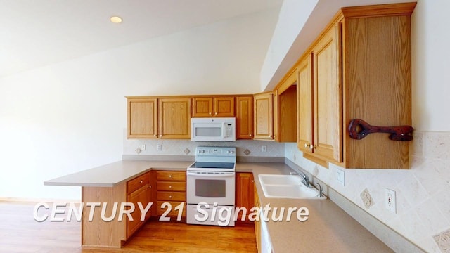 5966 Red Feather Dr, Bay City, MI 48706 - kitchen featuring white appliances, a sink, light countertops, a peninsula, and backsplash