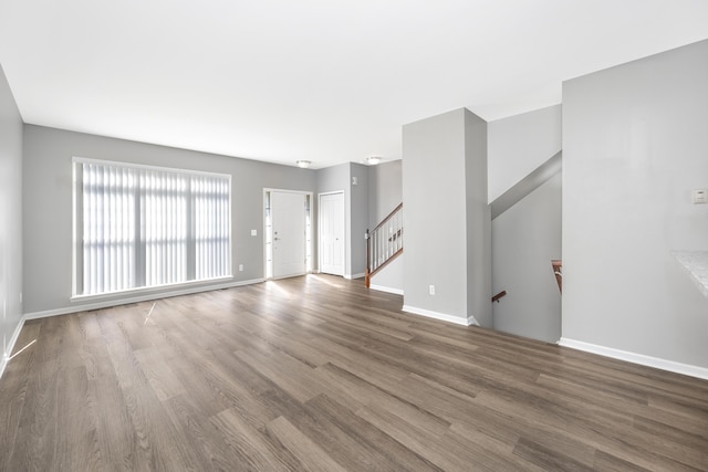 187 Center Blvd, Wixom, MI 48393 - unfurnished living room with wood finished floors, baseboards, and stairway