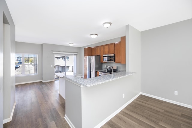 187 Center Blvd, Wixom, MI 48393 - kitchen featuring appliances with stainless steel finishes, brown cabinetry, dark wood finished floors, and baseboards
