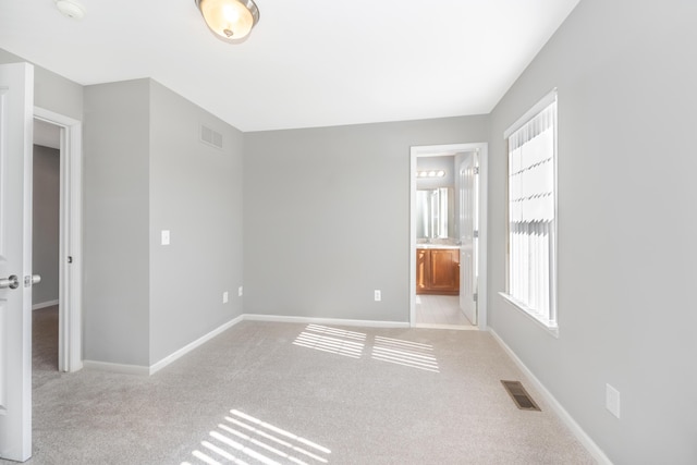187 Center Blvd, Wixom, MI 48393 - unfurnished bedroom featuring carpet floors, baseboards, and connected bathroom