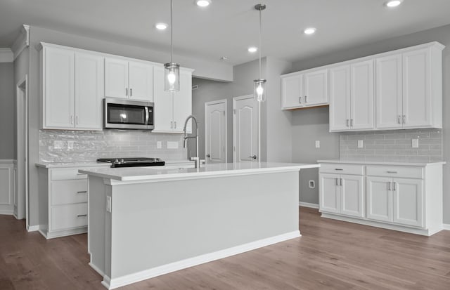 4076 Nottingham Cir, Clarkston, MI 48346 - kitchen featuring stainless steel microwave, tasteful backsplash, white cabinetry, light wood-type flooring, and light countertops