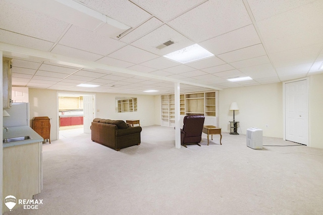 living area with light carpet and a drop ceiling
