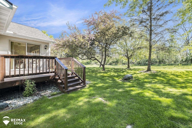 view of grassy yard featuring a wooden deck