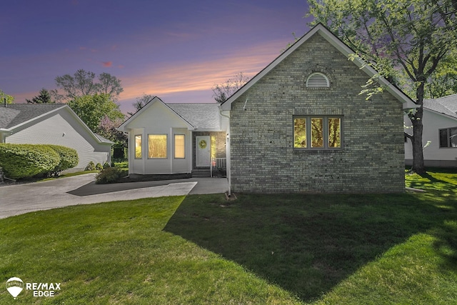view of front of property with brick siding and a front lawn