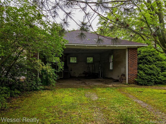 337 Chandler St, Romeo, MI 48065 - back of property featuring a carport, a lawn, and driveway