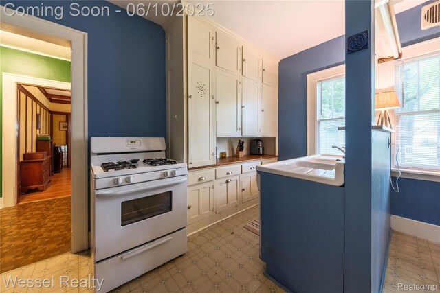 337 Chandler St, Romeo, MI 48065 - kitchen featuring white range with gas stovetop, white cabinets, and plenty of natural light