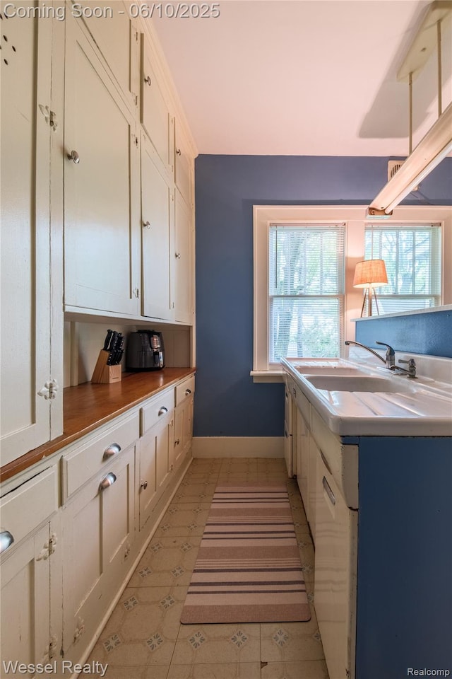 337 Chandler St, Romeo, MI 48065 - kitchen with a sink, white cabinetry, and baseboards