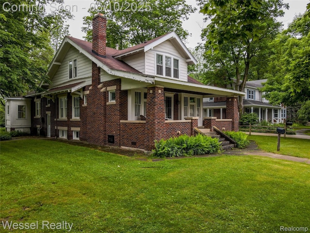 337 Chandler St, Romeo, MI 48065 - view of front of house featuring covered porch, a front yard, a chimney, and brick siding