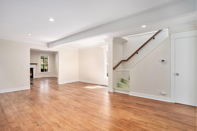 unfurnished living room with light wood finished floors, stairway, recessed lighting, crown molding, and baseboards
