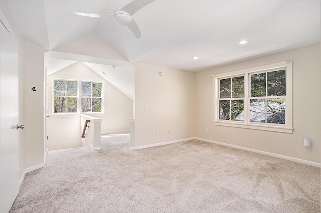 unfurnished room with carpet floors, healthy amount of natural light, ceiling fan, lofted ceiling, and baseboards