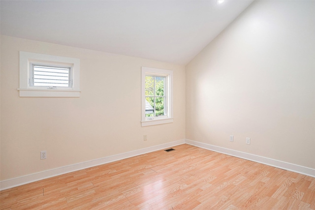 empty room with light wood-type flooring, baseboards, vaulted ceiling, and recessed lighting