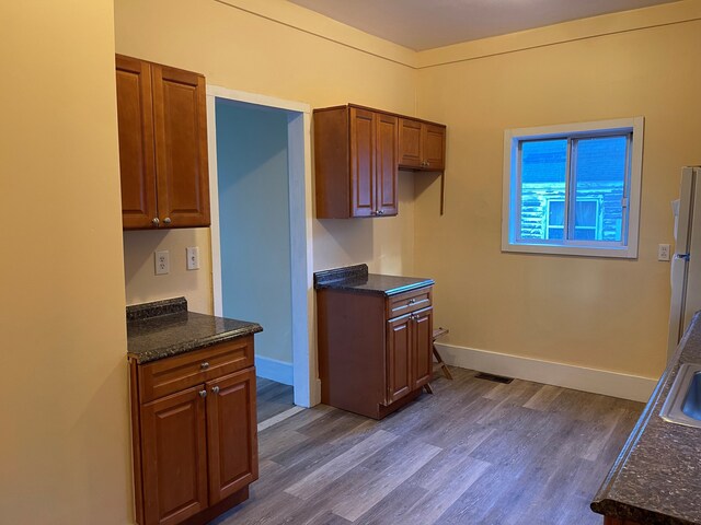 50 Henderson St, Pontiac, MI 48341 - kitchen featuring dark wood-style floors, dark stone counters, and baseboards