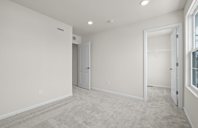 4080 Nottingham Cir, Clarkston, MI 48346 - unfurnished bedroom featuring light carpet, a walk in closet, baseboards, recessed lighting, and multiple windows