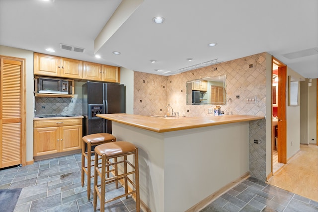 343 Shotwell, White Lake, MI 48386 - kitchen featuring black appliances, a kitchen breakfast bar, butcher block counters, decorative backsplash, and recessed lighting
