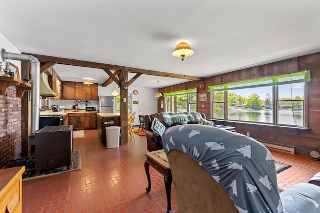 15065 Becker Dr, Mecosta, MI 49332 - living area featuring brick flooring, wood walls, beam ceiling, a baseboard radiator, and a water view
