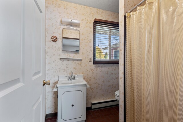 15065 Becker Dr, Mecosta, MI 49332 - full bath with baseboard heating, wallpapered walls, brick patterned flooring, toilet, and vanity