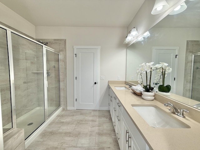 bathroom with a stall shower, double vanity, and baseboards
