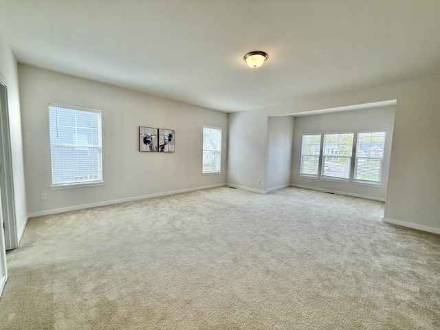 carpeted spare room featuring baseboards