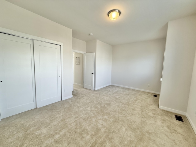 unfurnished bedroom with carpet, baseboards, and a closet