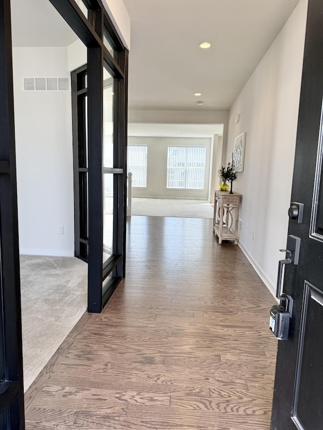 hall with wood finished floors, recessed lighting, and baseboards